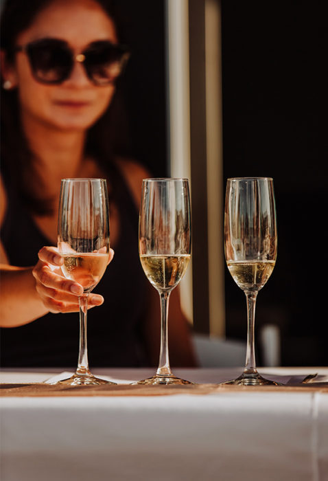 a woman about to grab a glass of champagne