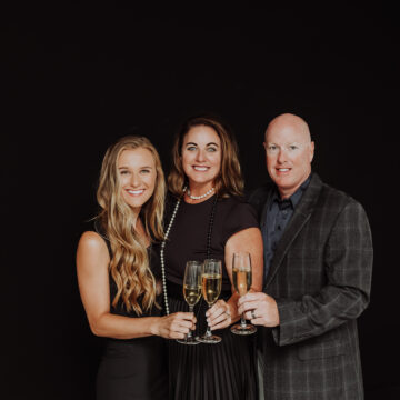 Three people posing for a picture with champagne glasses. Celebrating the birth of The Grant Collection, a brand that offers unforgettable experiences.