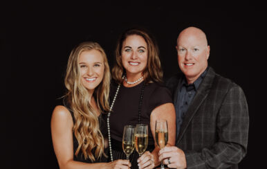 Three people posing for a picture with champagne glasses. Celebrating the birth of The Grant Collection, a brand that offers unforgettable experiences.