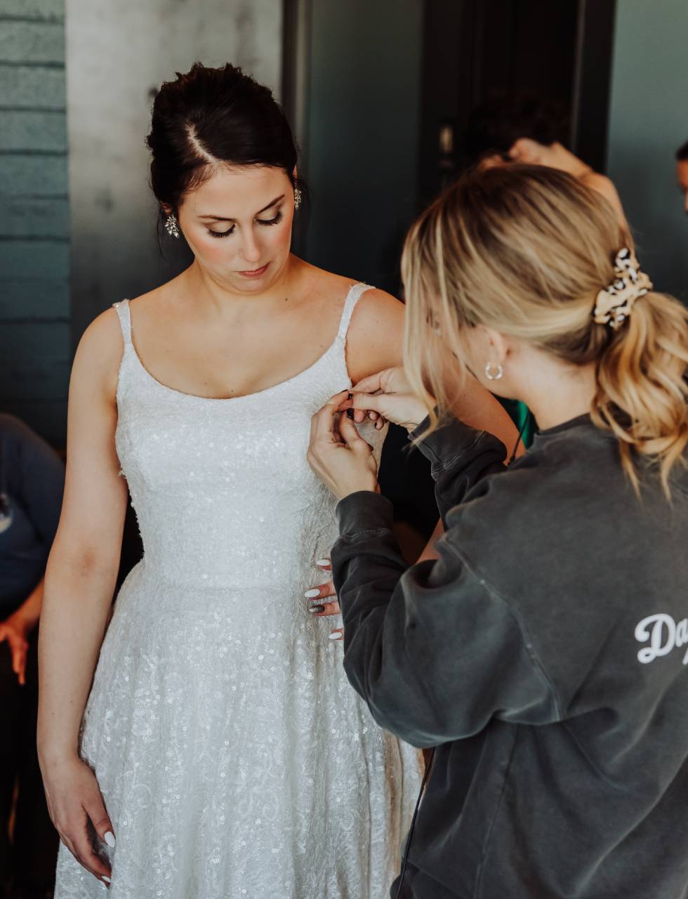 Day of coordinator at port 393 helping a bride with her wedding dress